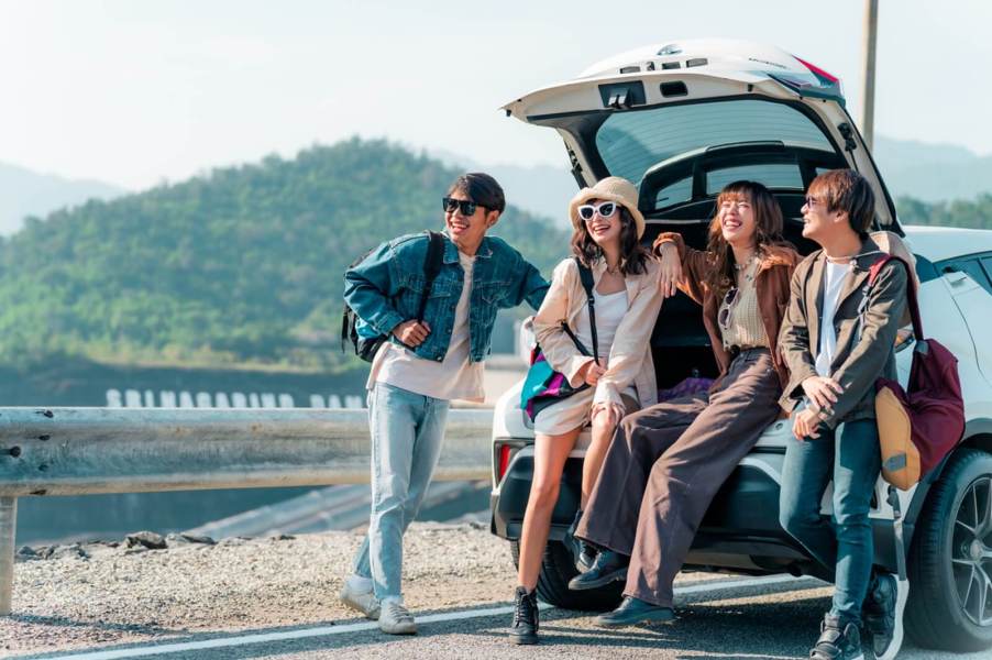 A group of friends smile during a safe stop on a road trip.