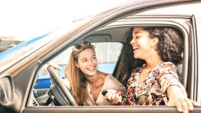 A set of teenagers sit in a car, each with a driver's license.