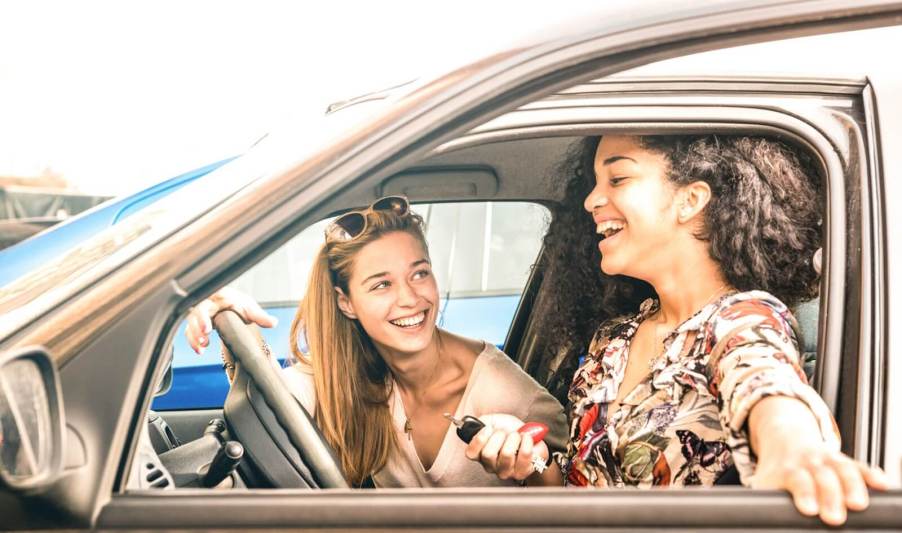 A set of teenagers sit in a car, each with a driver's license.