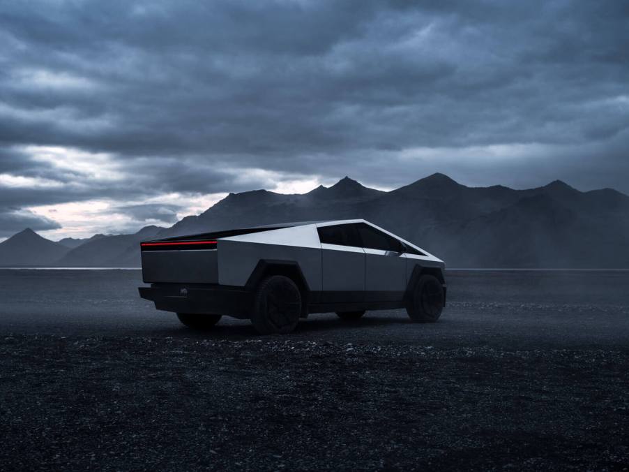 A Tesla Cybertruck in the desert under cloudy skies.