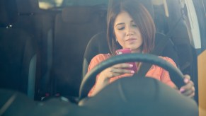 Woman texting while driving her car.