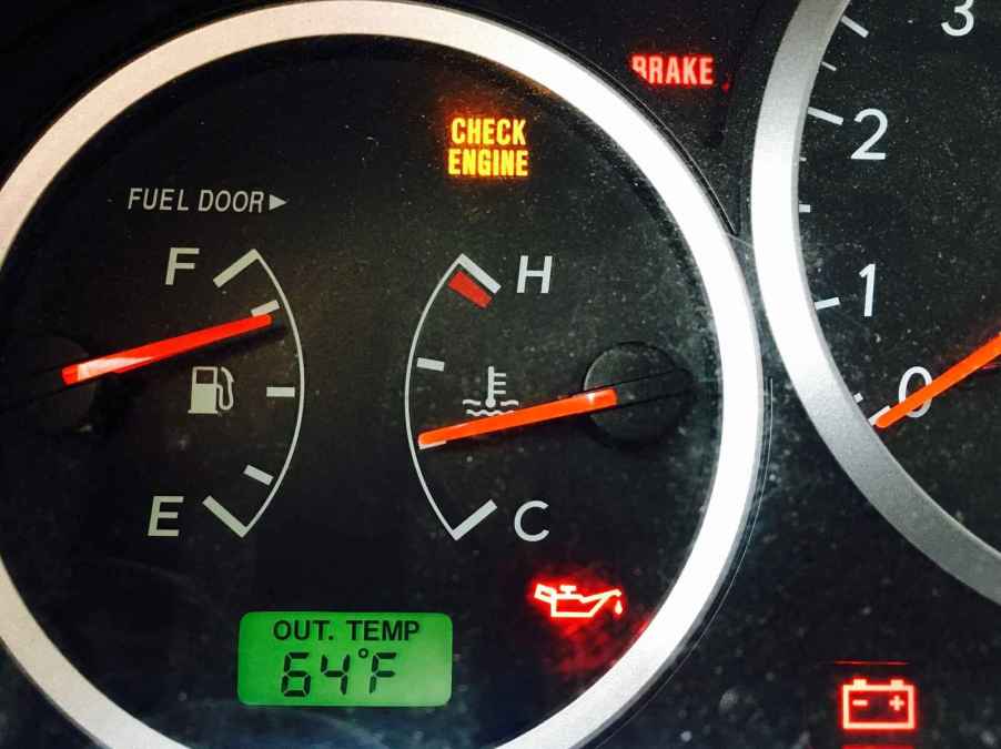 A check engine, brake, oil, and battery dash light inside a car in very close view