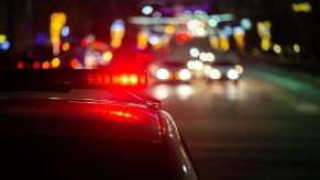 Representation of a DUI checkpoint at night police car roof light in close view blurred cars in background