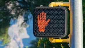 A red hand signal at a traffic light stops jaywalkers