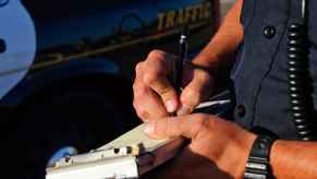 A police officer issuing a traffic ticket in very close view