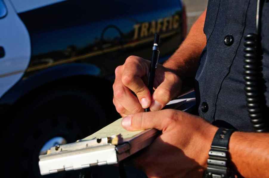 A police officer issuing a traffic ticket in very close view