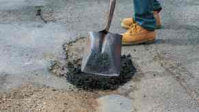 Volunteer fills in a pothole in Austin Texas