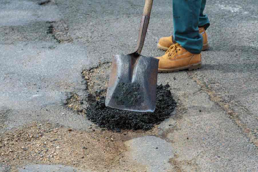 Volunteer fills in a pothole in Austin Texas