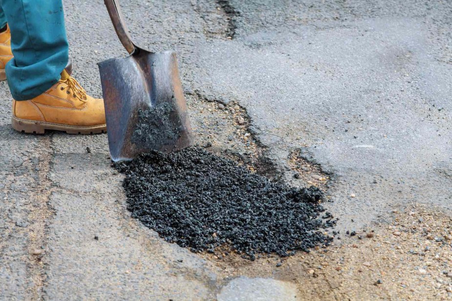 Volunteer fills in a pothole in Austin Texas