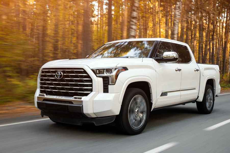 A white Toyota Tundra full-size pickup truck driving in left front angle view