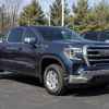 A dark blue 2022 GMC Sierra truck parked outside in right front angle view at a dealership lot