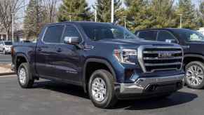 A dark blue 2022 GMC Sierra truck parked outside in right front angle view at a dealership lot