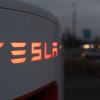 A Tesla charger, like the ones that could charge the Tesla Robotaxi, is illuminated in the dark.