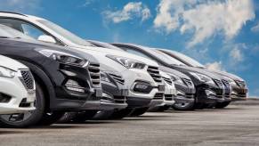 A row of new cars at a dealership for shoppers to use car-buying tips to shop.