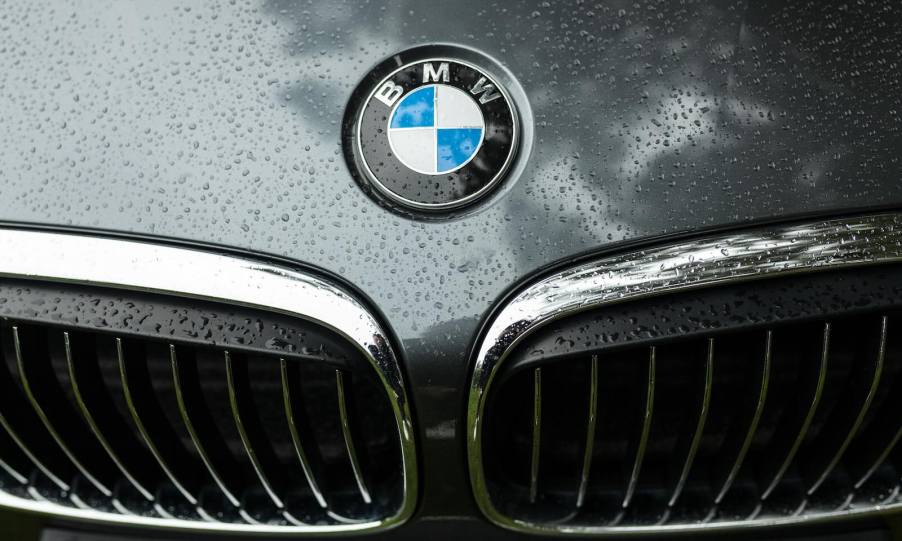 The BMW logo and kidney grille of a 550i sedan covered in rain.