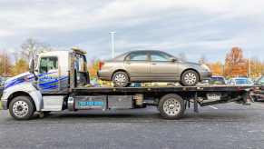 Car on a flat bed tow truck.