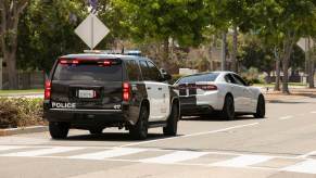 A Dodge Charger is pulled over by a police officer.