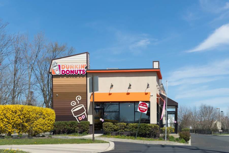 Tan Dunkin Donuts restaurant franchise, a blue sky visible in the background.