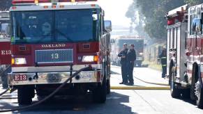 Oakland firefighters with their apparatuses and equipment, including the Jaws of Life.