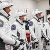 Four international and NASA astronauts who were the ISS crew for 200 days smile while suiting up.