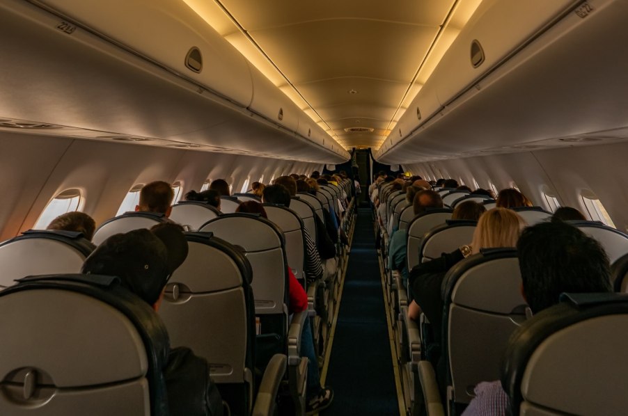 Passengers in the cabin of a jet airplane during an international flight.