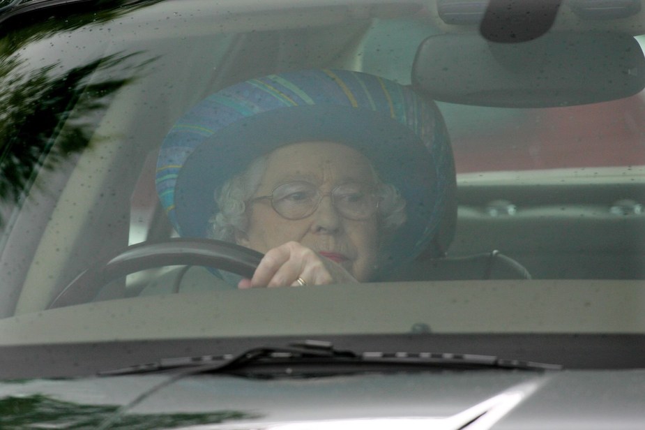 The Queen of England, Elizabeth II, drives her Jaguar car on the palace grounds