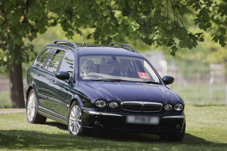 The Queen parked off-road in her black Jaguar X-Type estate car.