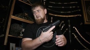 The head of Chechnya shows off his firearm collection, holding a pistol.