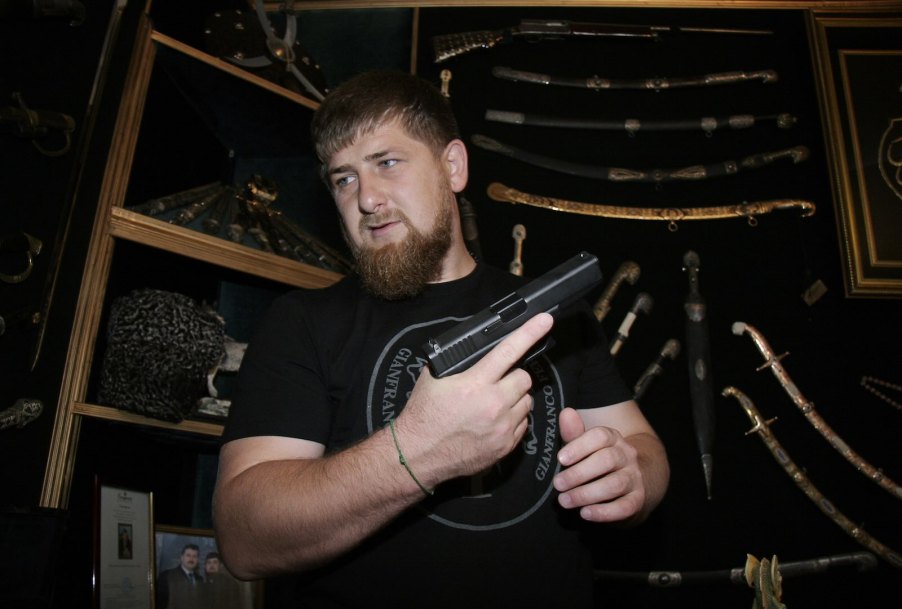 The head of Chechnya shows off his firearm collection, holding a pistol.