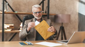 Man opens envelop with speeding ticket.