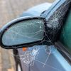 A parked car shows spider webs belonging to a spider that may give some drivers a reason to resort to jumping from a car.