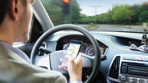 Man texts on his phone while parked at a stoplight.