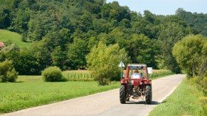 A farmer driving a tractor down the road