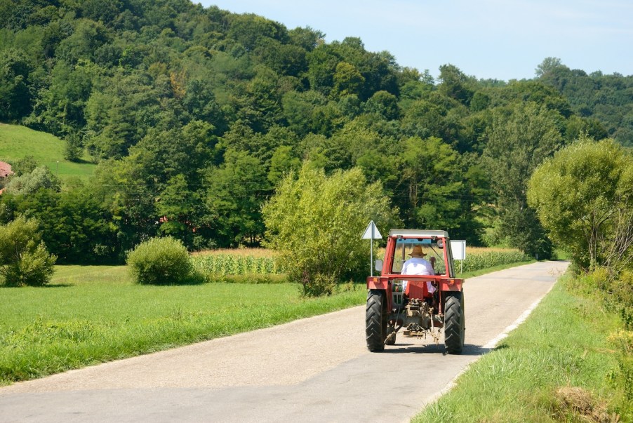 A farmer driving a tractor down the road