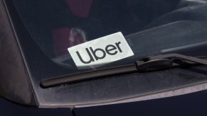 White "Uber" sticker in the windshield of a black car.