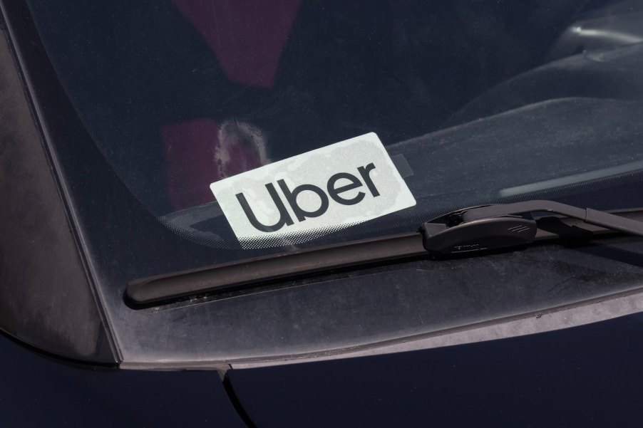 White "Uber" sticker in the windshield of a black car.