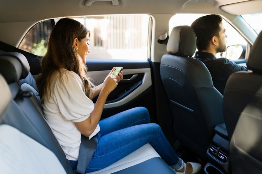 An Uber driver takes a passenger on for a fare.