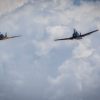 WWII airplanes fly next to one another in a color image.