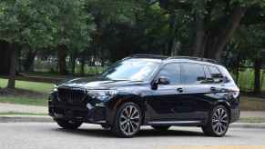 A black BMW X5 luxury SUV parked on a street in left profile view