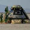 The Boeing Starliner landing in New Mexico in 2022 after an unmanned flight test with NASA staff wearing green hazmat suits outside the craft