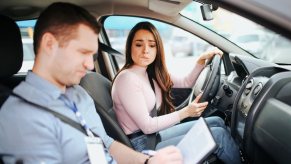 Teen looks concerned while a driving instructor fails her test