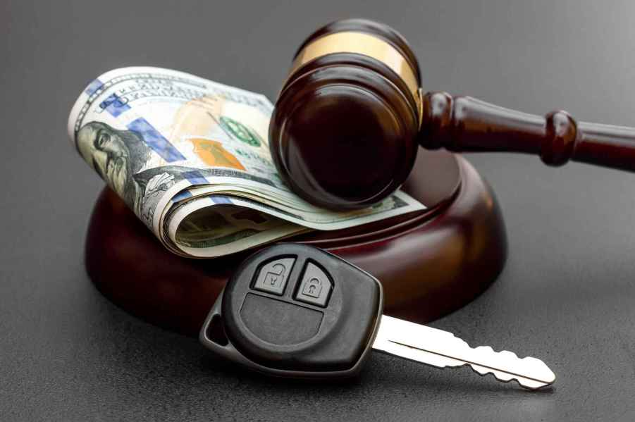 Depiction of attorney car insurance judgement using a gavel with folded paper money and car key