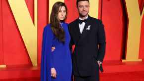 Justin Timberlake wearing tuxedo with wife Jessica Biel wearing long blue dress on Vanity Fair event red carpet