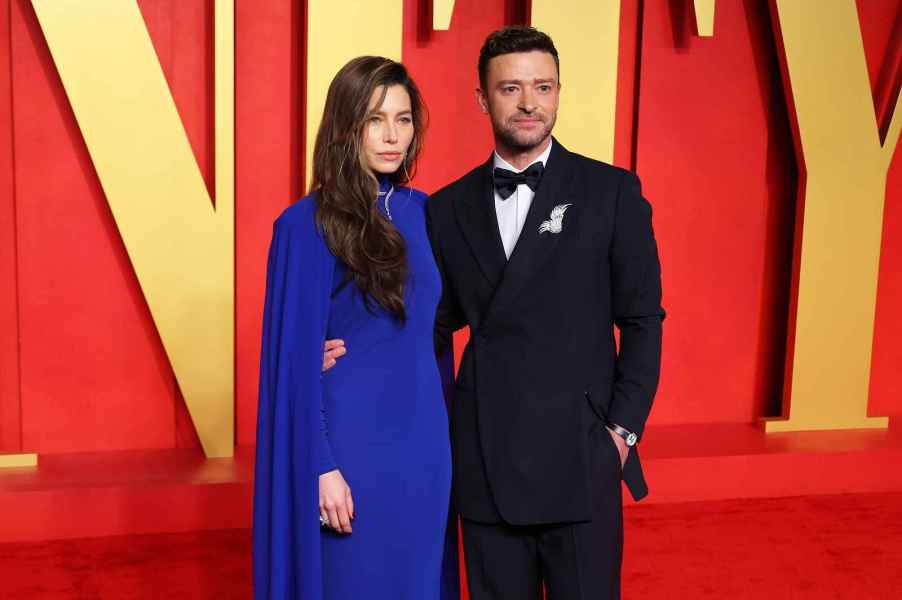 Justin Timberlake wearing tuxedo with wife Jessica Biel wearing long blue dress on Vanity Fair event red carpet