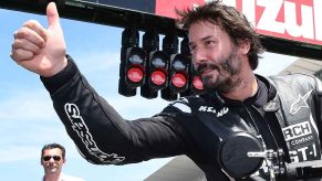 Keanu Reeves riding a motorcycle giving thumbs up