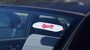 A Lyft rideshare sticker in a car's rear windshield in close view