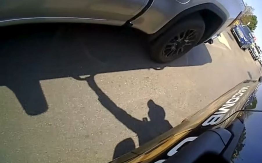 The shadow of a Macomb County sheriff's deputy reaches for a moving GMC Sierra