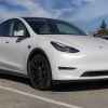 Pearl White Tesla Model Y parked in right front angle view in a parking lot