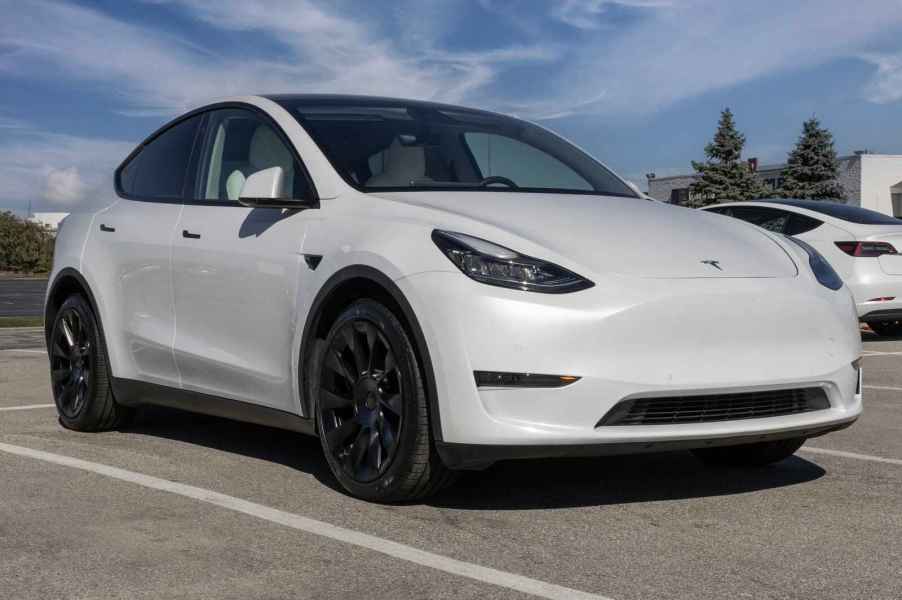 Pearl White Tesla Model Y parked in right front angle view in a parking lot