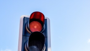 Red traffic light against the blue sky.